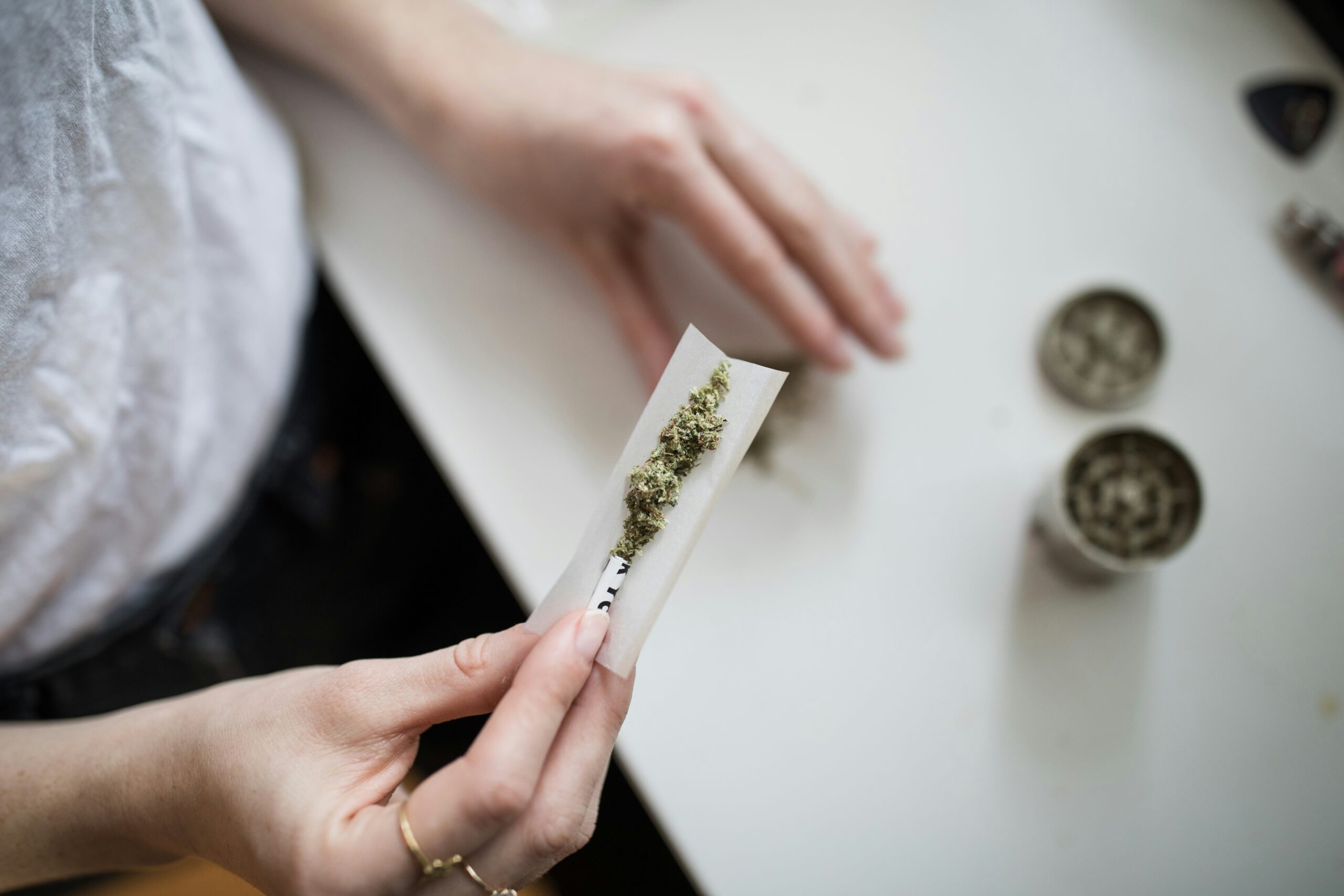 Junge Frauenhände bauen einen Joint